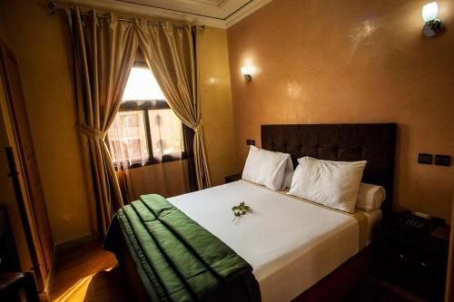 Charming apartment - secure and close to Marrakech no69 في تهنوت: غرفة نوم مع سرير أبيض كبير مع نافذة