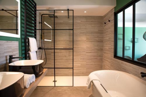 ein Badezimmer mit einer Badewanne und einem Waschbecken in der Unterkunft Manoir le Roure in Châteauneuf-du-Rhône