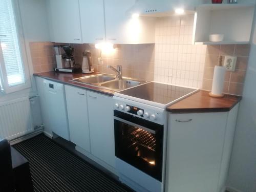 a kitchen with a stove and a sink and a oven at Majoituspalvelu Nurmi Apartment Peipontie 3 B in Raahe