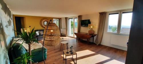 - un salon avec un canapé, une table et des fenêtres dans l'établissement Gîtes des lacs - Pinatelle - Durtol, à Durtol