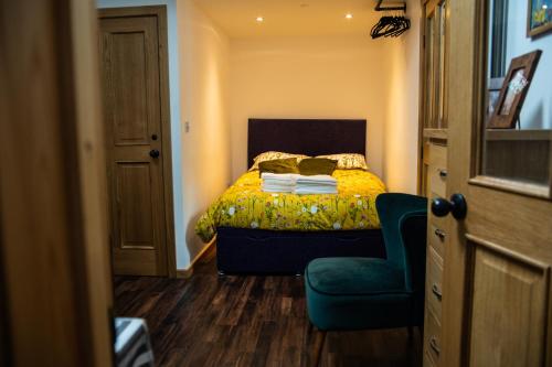 um pequeno quarto com uma cama e uma cadeira em The Rum Shack Manorbier Castle Inn em Manorbier