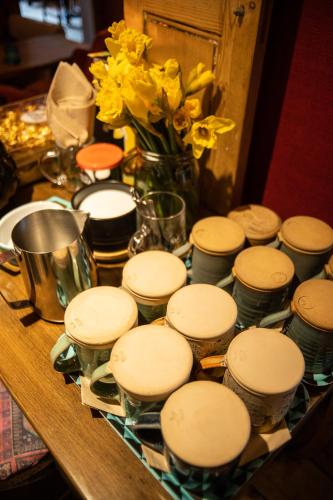 a table with a bunch of dishes and a vase of flowers at The Rum Shack Manorbier Castle Inn in Manorbier