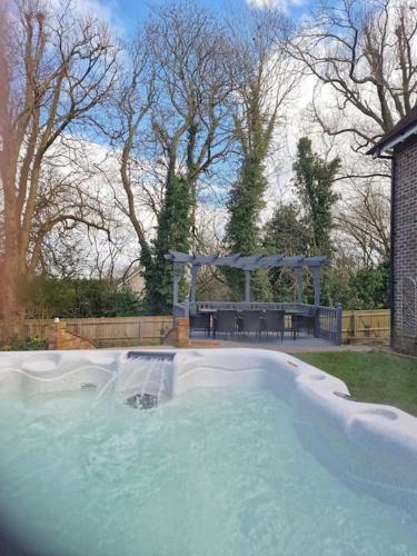 a swimming pool with a gazebo in a yard at Large coastal cottage,with private indoor pool, hut tub on the Jurassic coast in Weymouth
