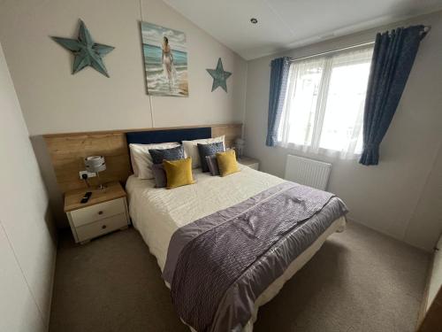 a bedroom with a bed with stars on the wall at Kestral Court Lodge, Scratby - California Cliffs, Parkdean, sleeps 6, bed linen and towels included, wrap around decking - no pets in Scratby