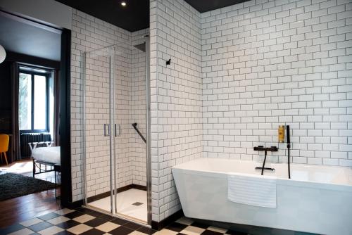 a bathroom with a tub and a glass shower at Manoir le Roure in Châteauneuf-du-Rhône