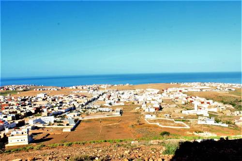 an aerial view of a village on a hill near the ocean at Asunfou : Appartement d'apaisement in Mirleft