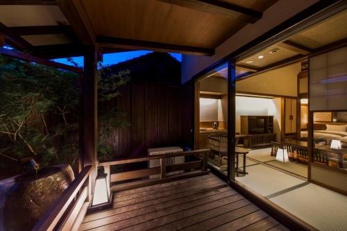 a room with a wooden deck with a bedroom at Inishie no Yado Keiun in Izumo