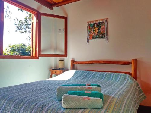 a bedroom with a bed with two towels on it at Casa da Lua Estrela in Visconde De Maua