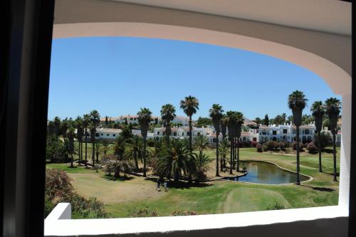 a view of a golf course from a window at Renovated Vale do Milho Golf Apartment with sea view in Carvoeiro