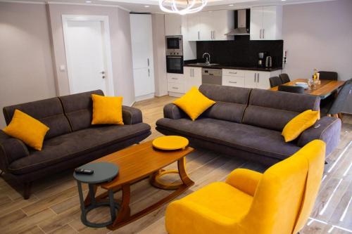 uma sala de estar com 2 sofás e uma mesa com almofadas amarelas em Vacation home with private pool, Fethiye, Oludeniz em Cedit
