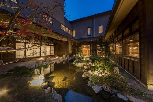 a building with a pond in front of a building at Inishie no Yado Keiun in Izumo