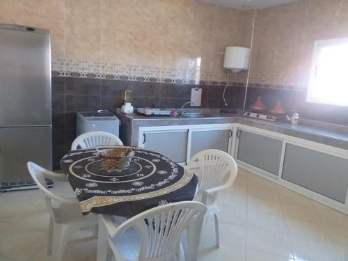 a kitchen with a table and chairs and a counter at Appartement à louer Tiznit 1 in Tiznit