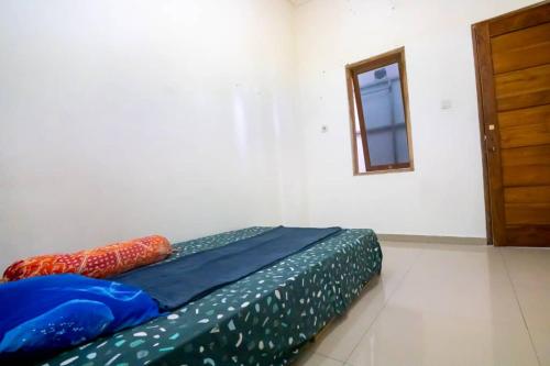 un letto in una camera con finestra e porta di Nova Jar a Dili