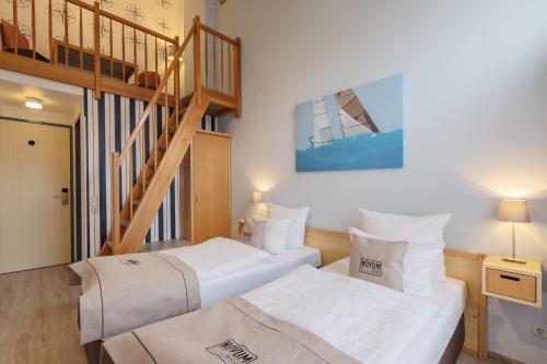 2 Betten in einem Zimmer mit einer Treppe in der Unterkunft Novum Akademiehotel Kiel in Kiel