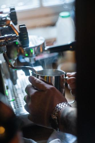 a person holding a cup in their hands at The Rum Shack Manorbier Castle Inn in Manorbier