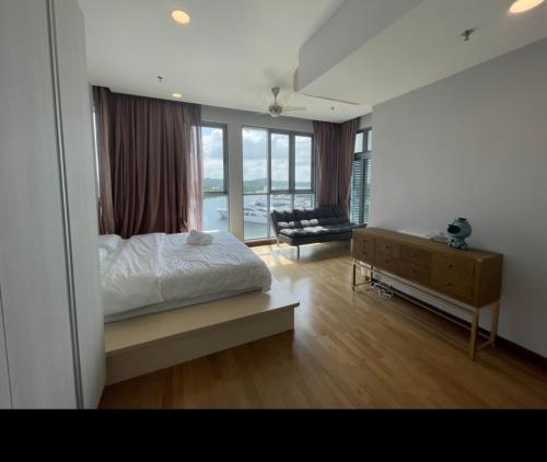 a bedroom with a bed and a couch and a window at Lux 3BR max 16pax Suite Puteri Habour sea view near Legoland in Nusajaya