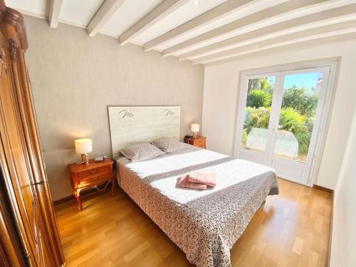 ein Schlafzimmer mit einem großen Bett und einem Fenster in der Unterkunft Villa DAMALIX front de mer 5 pax Plage in Saint-Raphaël