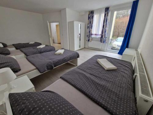 Cette chambre comprend 4 lits et une fenêtre. dans l'établissement Ferienwohnung mit Smart-TV, à Burscheid