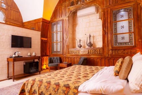 - une chambre avec un lit et une télévision dans l'établissement Reji Boutique Hotel, à Şanlıurfa