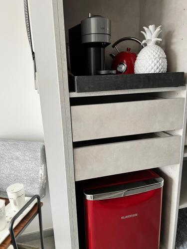 - une étagère dans une cuisine équipée d'un réfrigérateur rouge dans l'établissement Eclipse Rochelongue, au Cap d'Agde