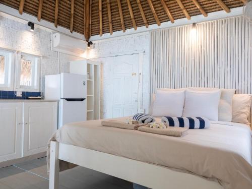 a bedroom with a large bed with towels on it at Seaside Cottage, Gili Air in Gili Islands