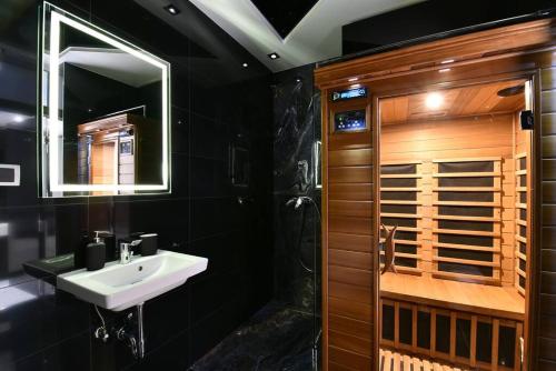 a black bathroom with a sink and a shower at Lux Spa Apartman na Vračaru in Vračar (historical)