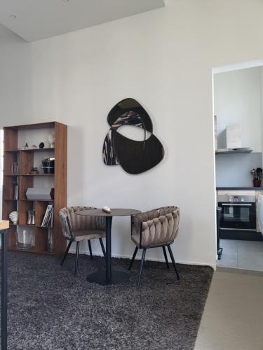 une table avec deux chaises et un chapeau sur le mur dans l'établissement Studio Terrasse, ancienne maison de champagne, à Reims