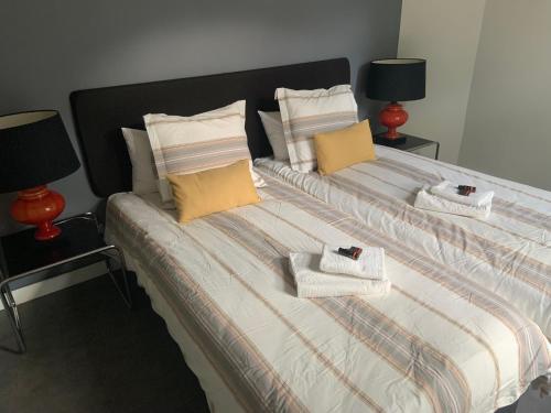 HS68-apartment في ماستريخت: غرفة نوم بسريرين تحتوي على مناشف ومصابيح
