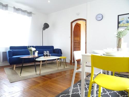 sala de estar con sofá azul y sillas amarillas en Square-bnb - Duplex à 10min de Disneyland Paris, en Montévrain