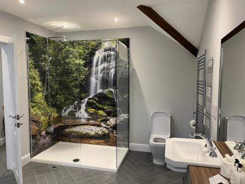 uma casa de banho com uma pintura de cascata na parede em The Stables with Hot Tub em Cray