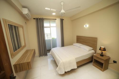 a hotel room with a bed and a window at BNB RESIDENCIES MOUNT LAVINIA in Mount Lavinia