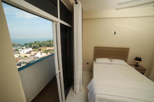 a bedroom with a bed and a large window at BNB RESIDENCIES MOUNT LAVINIA in Mount Lavinia