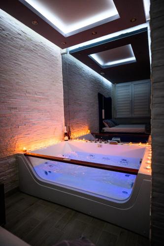a large bathroom with a large tub with lights at Spa Apartman Grand in Niš