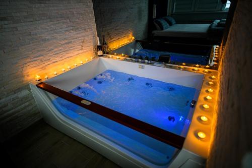 a blue tub with lights in a room at Spa Apartman Grand in Niš