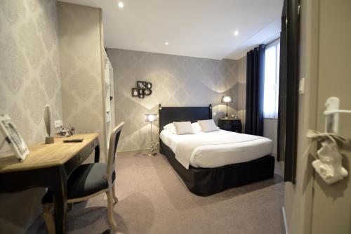 um quarto de hotel com uma cama e uma secretária em France Hôtel em Niort