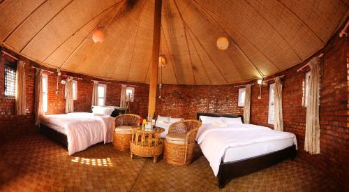 a bedroom with two beds and a brick wall at Rock Garden Resort in Pokhara