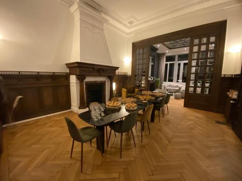 a dining room with tables and chairs and a fireplace at Maison Mimerel Colodge in Roubaix