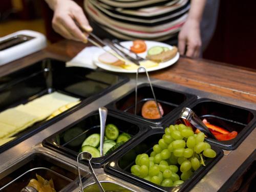 a person is preparing a plate of food with grapes at Kauppahotelli in Lahti