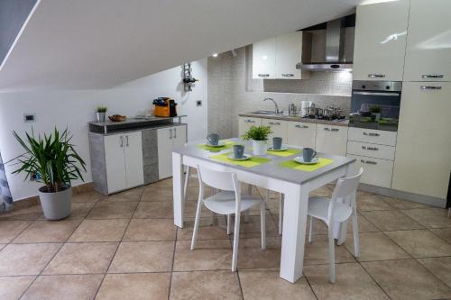 - une cuisine avec une table blanche et des chaises blanches dans l'établissement Attic A31 apartament rooftop deluxe, à Santa Maria Capua Vetere
