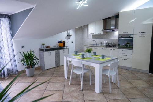 - une cuisine blanche avec une table et des chaises blanches dans l'établissement Attic A31 apartament rooftop deluxe, à Santa Maria Capua Vetere