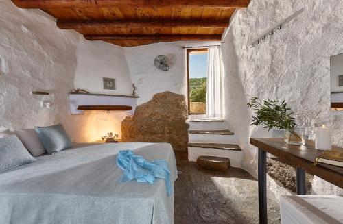 a bedroom with a bed and a window at White River Cottages - rustic minimalist holiday houses in Makry Gialos