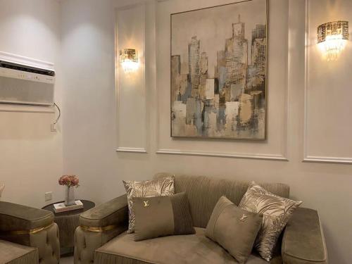 a living room with a couch and a painting on the wall at luxury apartment - Prince majed park in Jeddah