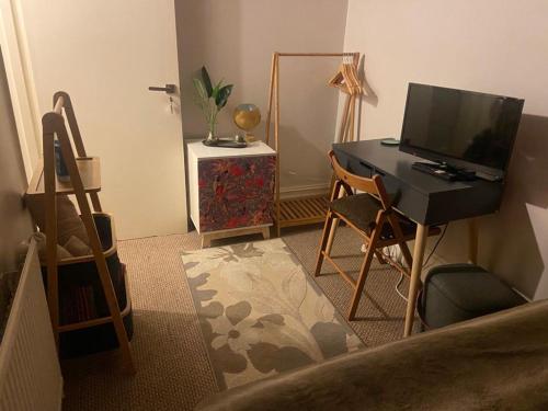 Zimmer mit einem Schreibtisch, einem Computer und einem Stuhl in der Unterkunft Cozy home in Croydon