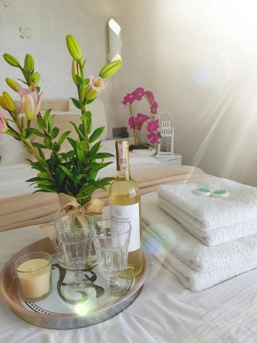 a bottle of wine on a tray with glasses and towels at Apartament & Spa 5 Mórz in Sianozety