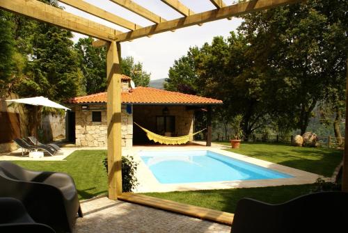 a backyard with a swimming pool and a house at Casa da Terra - Gerês in Geres