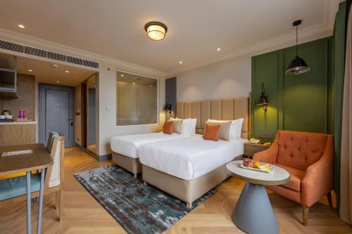 una camera d'albergo con letto, divano e tavolo di Sarovar Portico Srinagar a Srinagar
