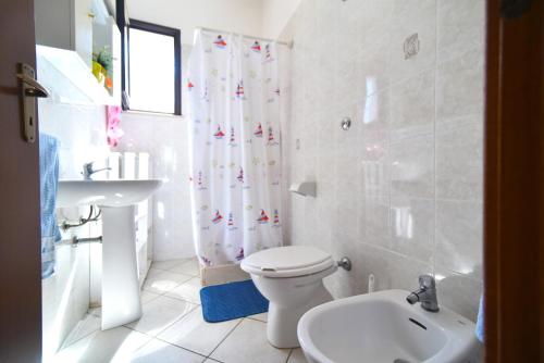 a white bathroom with a toilet and a sink at Piccolo Residence Gallipoli in Gallipoli