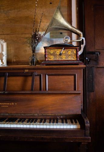 an old piano with a vase on top of it at Manorbier Castle Inn Bay Room in Manorbier
