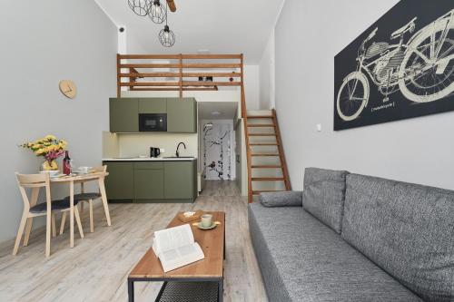 a living room with a couch and a table and a kitchen at Airport Studio Zarembowicza by Noclegi Renters in Wrocław