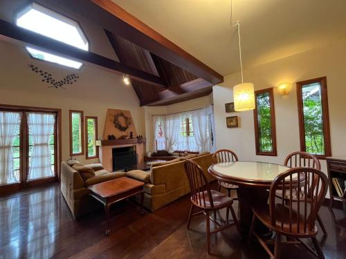 - un salon avec une table et un canapé dans l'établissement Villa di Caserta by Capivari Lodge Home, à Campos do Jordão